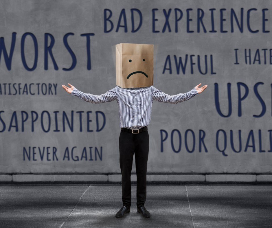 A person with a sad-face paper bag standing in front of words describing a bad experience.