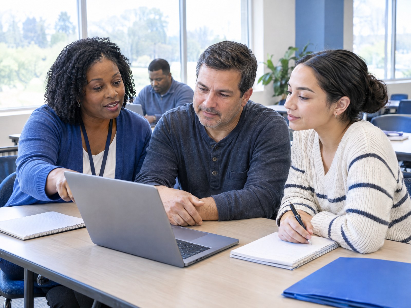 Workforce development instructor helping adults with a practical computer-learning exercise